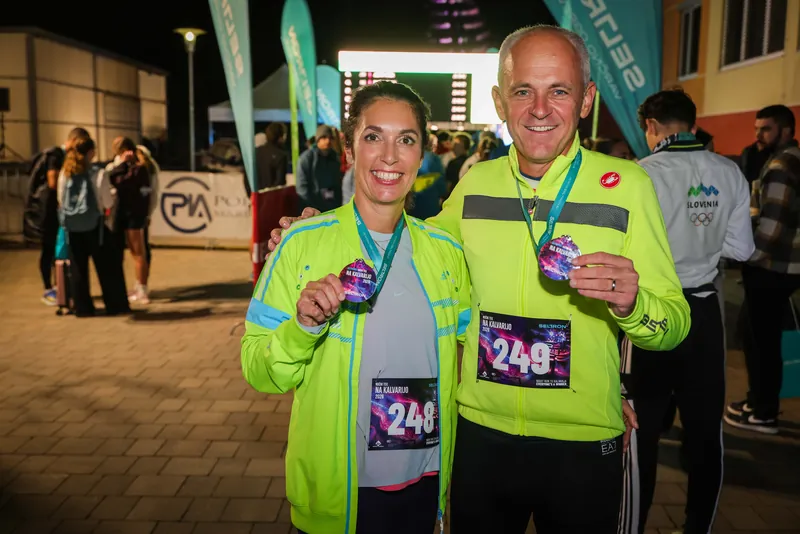 Udeleženca nočnega teka z medaljama po opravljenem izzivu