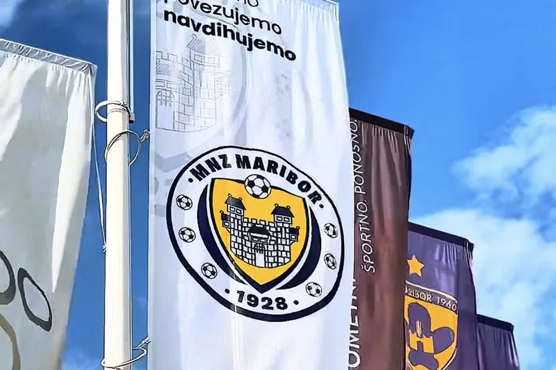 Nogometne zastave ob igrišču na Pobrežju, med njimi zastava MNZ Maribor.