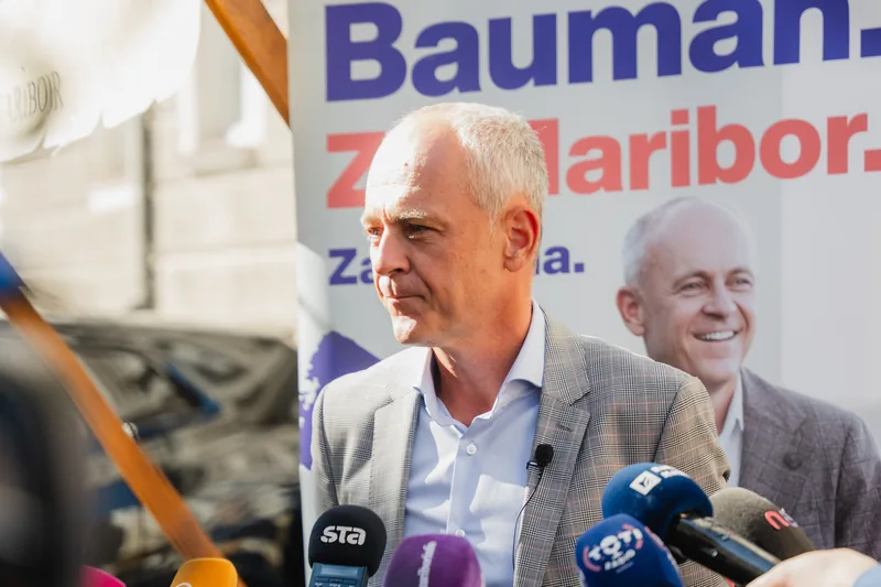 Andrej Bauman pred mikrofoni med izjavo ob zbranih podpisih podpore