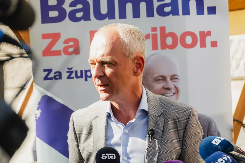 Andrej Bauman ob stojnici Bauman. Za Maribor. med izjavo za medije