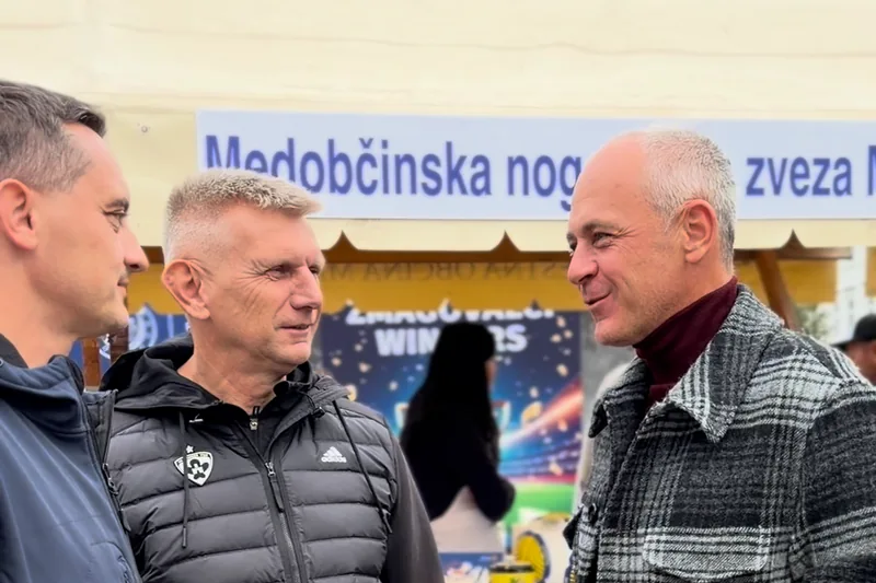 Pogovor obiskovalcev ob stojnici Medobčinske nogometne zveze Maribor.